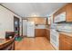 Bright kitchen with wood cabinets, white appliances, and laminate flooring at 37015 Sandra Ave, Zephyrhills, FL 33542