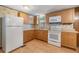 Galley kitchen with wood cabinets and white appliances at 37015 Sandra Ave, Zephyrhills, FL 33542