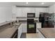 Open kitchen with white cabinets, black appliances, and granite countertops at 8958 White Sage Loop, Lakewood Ranch, FL 34202