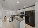 Kitchen boasts a large island, black appliances, and white cabinets at 8958 White Sage Loop, Lakewood Ranch, FL 34202