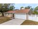 Tan house with white garage door and white privacy fence at 102 Shoreview Ln, Oldsmar, FL 34677
