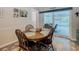 Dining area with wood table and four chairs, and sliding door leading to the backyard pool at 13100 Pebble Beach Cir, Hudson, FL 34667