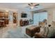 Open concept living room with kitchen access, brown couch, and two ottomans at 13100 Pebble Beach Cir, Hudson, FL 34667