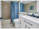 Bathroom with a tub shower, white vanity, and blue shower curtain at 2267 Heron Cir, Clearwater, FL 33762