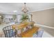 Bright dining room features a rustic wooden table with bench seating, chandelier, and views into the living room at 2267 Heron Cir, Clearwater, FL 33762