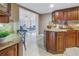 Kitchen boasts granite countertops, dark wood cabinets, and an island with seating. Open to Gathering room at 2267 Heron Cir, Clearwater, FL 33762