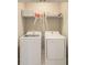 Bright laundry room with washer and dryer, plus shelving for storage at 2441 Foggy Creek Cir, Clearwater, FL 33764