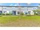 Back view of townhouses showcasing a grassy yard and screened patio at 2441 Foggy Creek Cir, Clearwater, FL 33764
