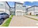 Front view of townhouses with gray siding and pavered driveways at 2441 Foggy Creek Cir, Clearwater, FL 33764