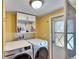 Laundry room with washer, dryer, and overhead storage at 3022 Short Leaf St, Wesley Chapel, FL 33543