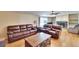 Living room with leather furniture, fireplace, and hardwood floors at 3022 Short Leaf St, Wesley Chapel, FL 33543