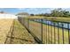 Black metal fence encloses backyard, offering privacy and overlooking a pond at 3409 77Th E Ct, Palmetto, FL 34221
