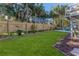 Landscaped backyard with wooden fence, lush lawn, and tropical plants at 3478 Gum Dr, Weeki Wachee, FL 34607