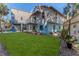 Large grassy backyard with spacious patio, colorful chairs, and fire pit at 3478 Gum Dr, Weeki Wachee, FL 34607