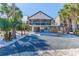 Two-story house with screened porch, gravel driveway, and tropical landscaping at 3478 Gum Dr, Weeki Wachee, FL 34607