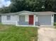 Cute one-story home with gray and white exterior, red door, and attached garage at 4605 Irene Loop, New Port Richey, FL 34652