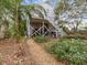 Landscaped backyard with gravel pathway, tropical plants, and a two-story home at 514 Wideview Ave, Tarpon Springs, FL 34689