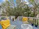 Spacious deck with blue flooring, yellow pillows and a glass-top table at 514 Wideview Ave, Tarpon Springs, FL 34689