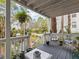 Relaxing front porch with white railings, wicker chairs, and potted plants at 514 Wideview Ave, Tarpon Springs, FL 34689