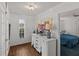 Hallway with hardwood floors, white dresser, and view of bedroom at 514 Wideview Ave, Tarpon Springs, FL 34689