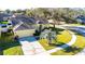 Aerial view of yellow house, driveway, and yard at 5215 New Brittany Ln, Zephyrhills, FL 33541