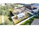 Aerial view of a house with a screened patio, fire pit, and fenced backyard at 5215 New Brittany Ln, Zephyrhills, FL 33541