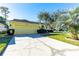 Yellow house with a two-car garage and a neatly landscaped front yard at 5215 New Brittany Ln, Zephyrhills, FL 33541