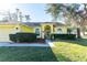 Charming yellow house with an arched entryway and well-maintained landscaping at 5215 New Brittany Ln, Zephyrhills, FL 33541