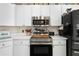 Updated kitchen with stainless steel appliances and white cabinetry at 5215 New Brittany Ln, Zephyrhills, FL 33541