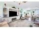 Open living room with a large TV, comfortable seating, and a view into the dining area at 5215 New Brittany Ln, Zephyrhills, FL 33541