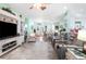 Spacious living room featuring a large TV, comfortable seating, and hardwood floors at 5215 New Brittany Ln, Zephyrhills, FL 33541