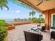 Spacious patio overlooking the water with wicker furniture at 5301 Gulf Blvd # E202, St Pete Beach, FL 33706