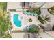Aerial view of resort-style pool, hot tub, patio, and lush landscaping at 5301 Gulf Blvd # E202, St Pete Beach, FL 33706