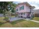 Pink two-story house with green trim, front porch, and pergola at 5901 N Cherokee Ave, Tampa, FL 33604