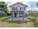Pink two-story house with green trim, front porch, and pergola at 5901 N Cherokee Ave, Tampa, FL 33604
