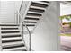 Modern dark wood staircase with metal railing and white walls at 6 Treasure Ln, Treasure Island, FL 33706