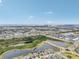 Wide aerial shot reveals a well-planned community layout with serene lakes, roadways, and distant industrial views at 6028 Milestone Dr, Apollo Beach, FL 33572