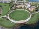 Aerial view of the community amenities featuring a lawn, playground, splashpad, and green space at 6028 Milestone Dr, Apollo Beach, FL 33572