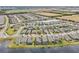 Scenic aerial perspective of a planned community, featuring homes surrounding a pond with green spaces and roadways at 6028 Milestone Dr, Apollo Beach, FL 33572