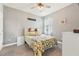 Bedroom with a ceiling fan, white furniture, and bright yellow and gray floral bedding at 6028 Milestone Dr, Apollo Beach, FL 33572