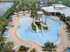 Aerial view of a luxurious community pool with water slides, lounge chairs, and lush landscaping at 6028 Milestone Dr, Apollo Beach, FL 33572
