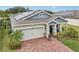 A well-maintained home with solar panels on the roof, brick driveway, and manicured landscaping at 6028 Milestone Dr, Apollo Beach, FL 33572