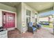Welcoming front porch with a swing, seating, and a decorative red front door at 6028 Milestone Dr, Apollo Beach, FL 33572