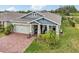 Charming home boasts a manicured lawn, brick driveway, and a cozy porch perfect for relaxing at 6028 Milestone Dr, Apollo Beach, FL 33572