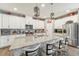 Modern kitchen with a granite-topped island with seating, tile floors, and stainless appliances at 6028 Milestone Dr, Apollo Beach, FL 33572
