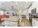 Open concept kitchen with bar top seating, stainless appliances and wood look tile at 6028 Milestone Dr, Apollo Beach, FL 33572