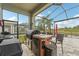 Screened in outdoor kitchen with grill, mini fridge and a view of the lake at 6028 Milestone Dr, Apollo Beach, FL 33572