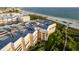 Aerial perspective of building, highlighting its beachfront location and ocean views at 6650 Sunset Way # 210, St Pete Beach, FL 33706