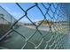 View of a tennis court through a chain link fence at 9209 Seminole Blvd # 209, Seminole, FL 33772