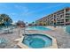 Community pool and hot tub with lounge chairs at 1 Key Capri # 112E, Treasure Island, FL 33706